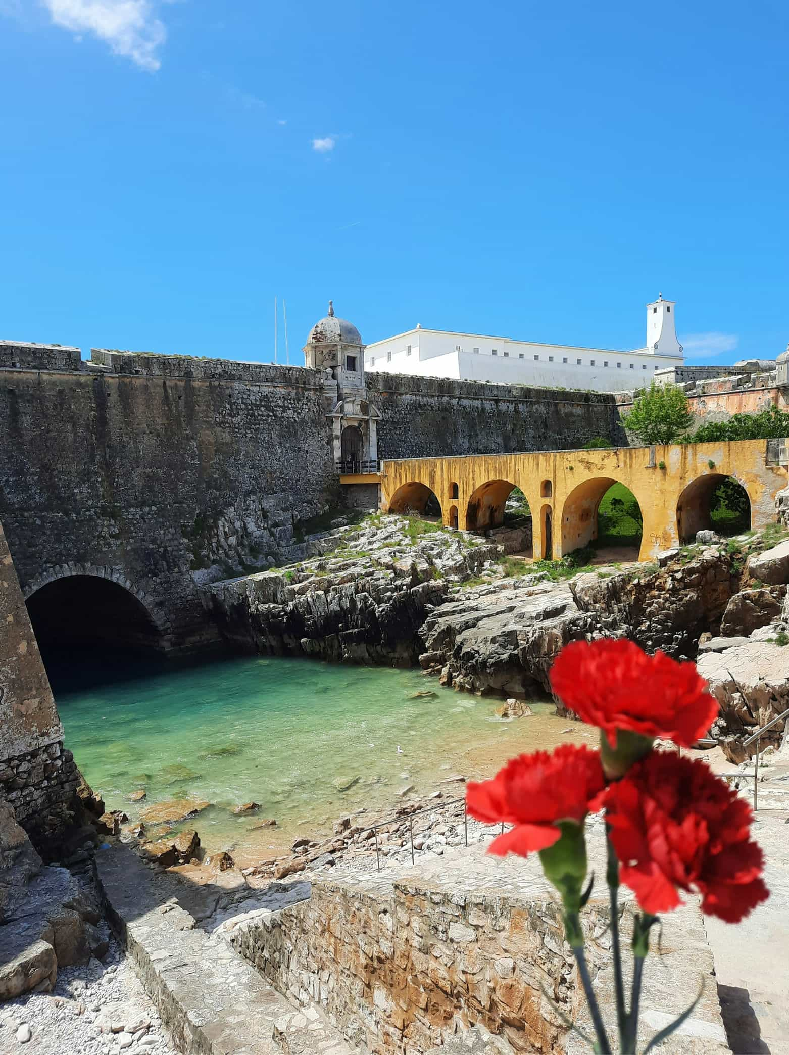 Foto da Prainha/Praia de S. Pedro e Fortaleza de Peniche com cravos do 25 de Abril