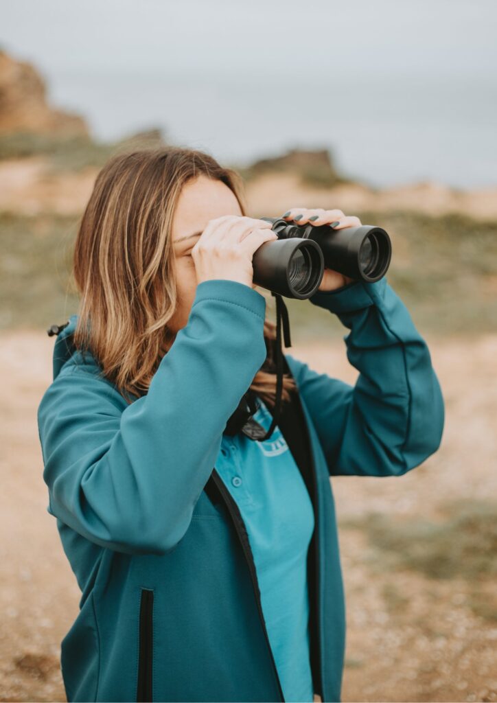 Diana Costa, guia da Peniche360 a segurar e ver através dos binóculos